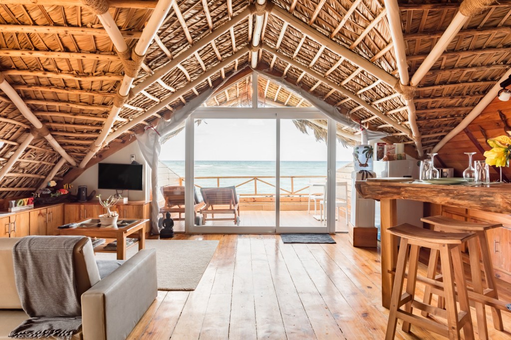 Living room of a tropical hut, with an outlook to the ocean. 