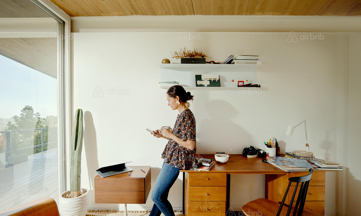 Woman using mobile phone in an at home office environment