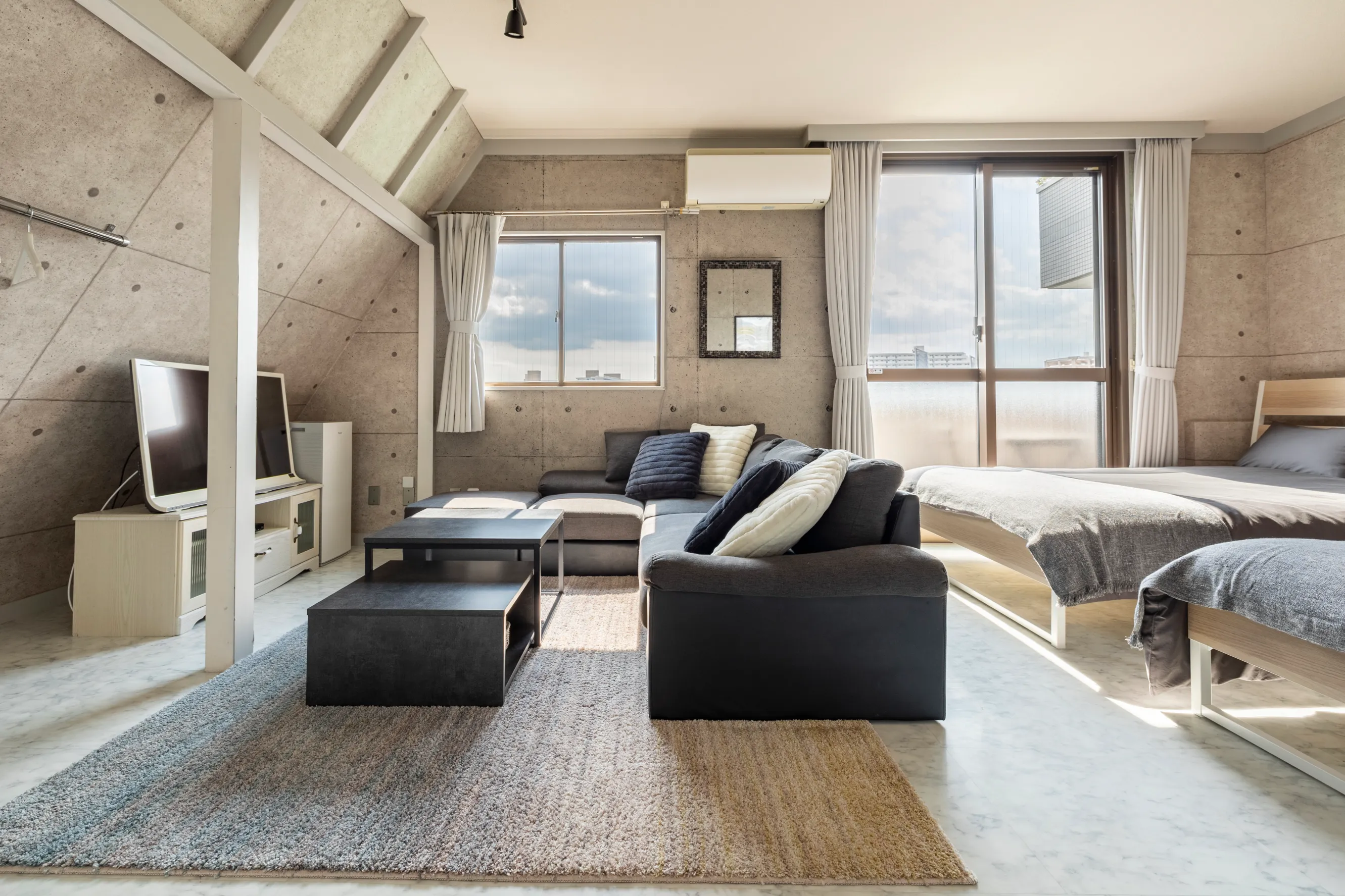 A gray bedroom and living room with blue accents