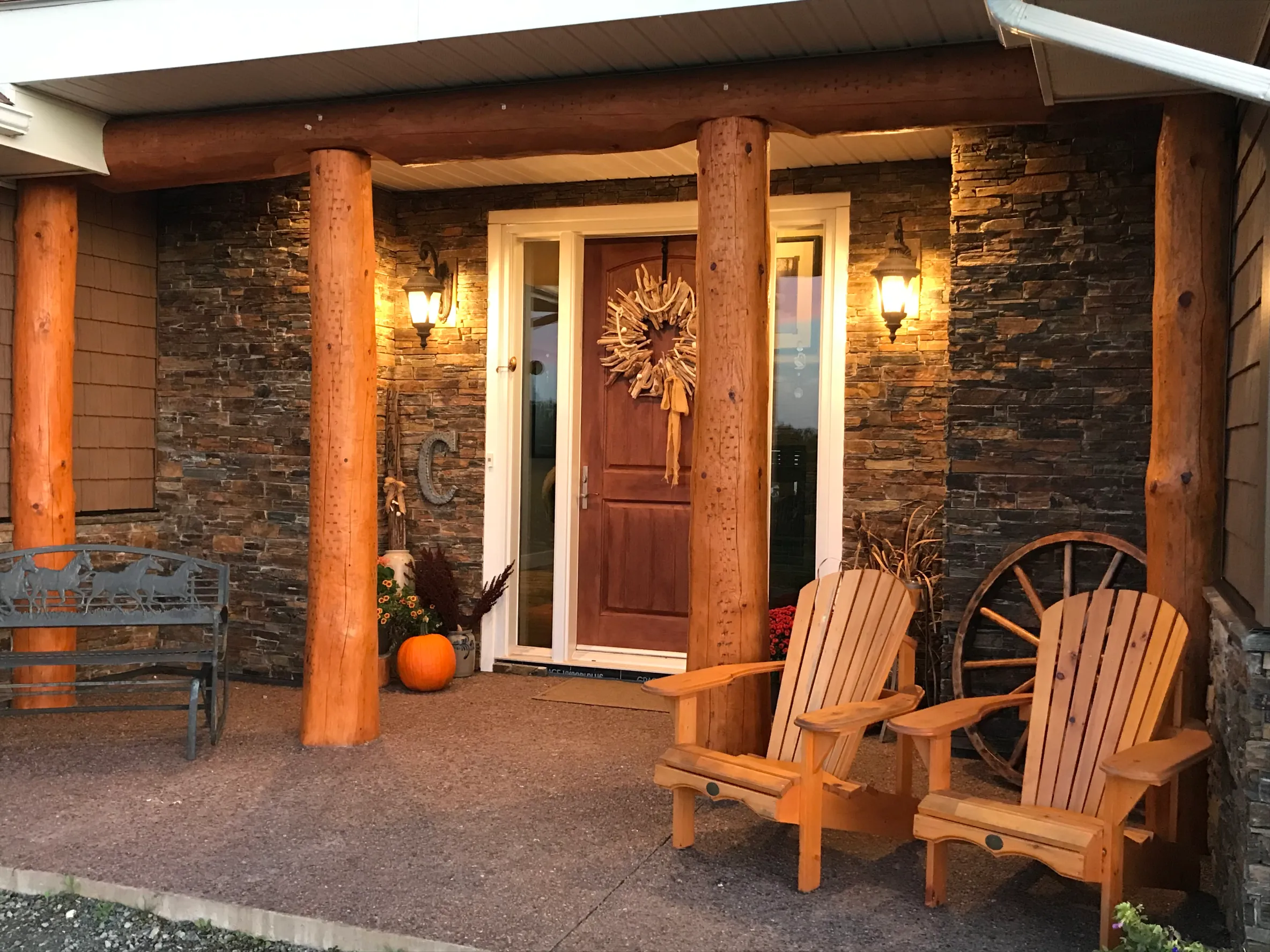 The porch of a wood and brick home in Nova Scotia with Muskoka Chairs