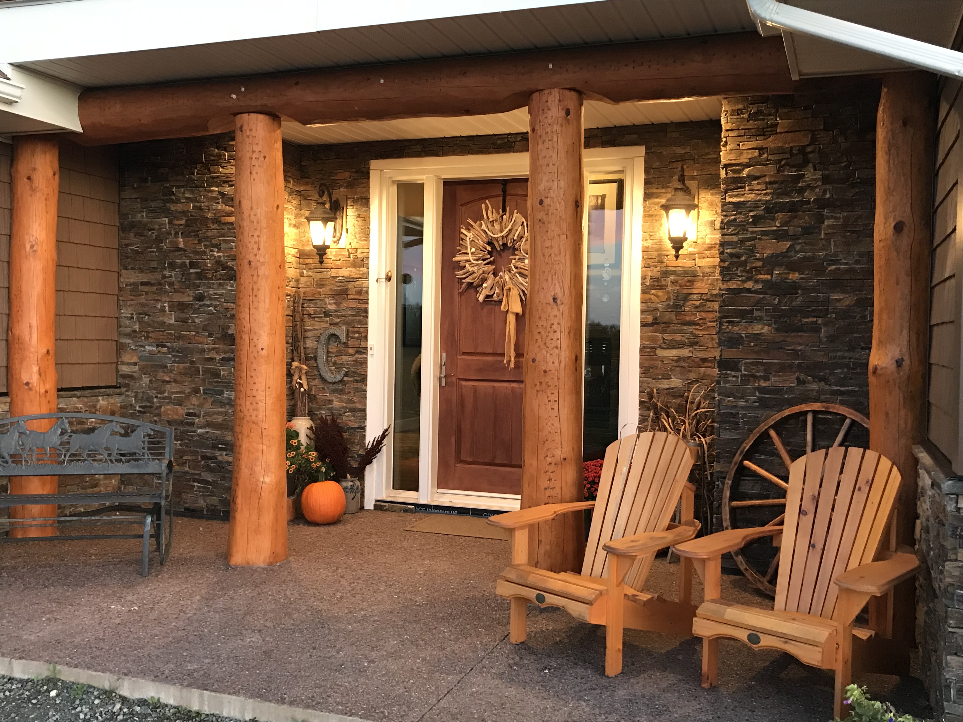 The porch of a wood and brick home in Nova Scotia with Muskoka Chairs