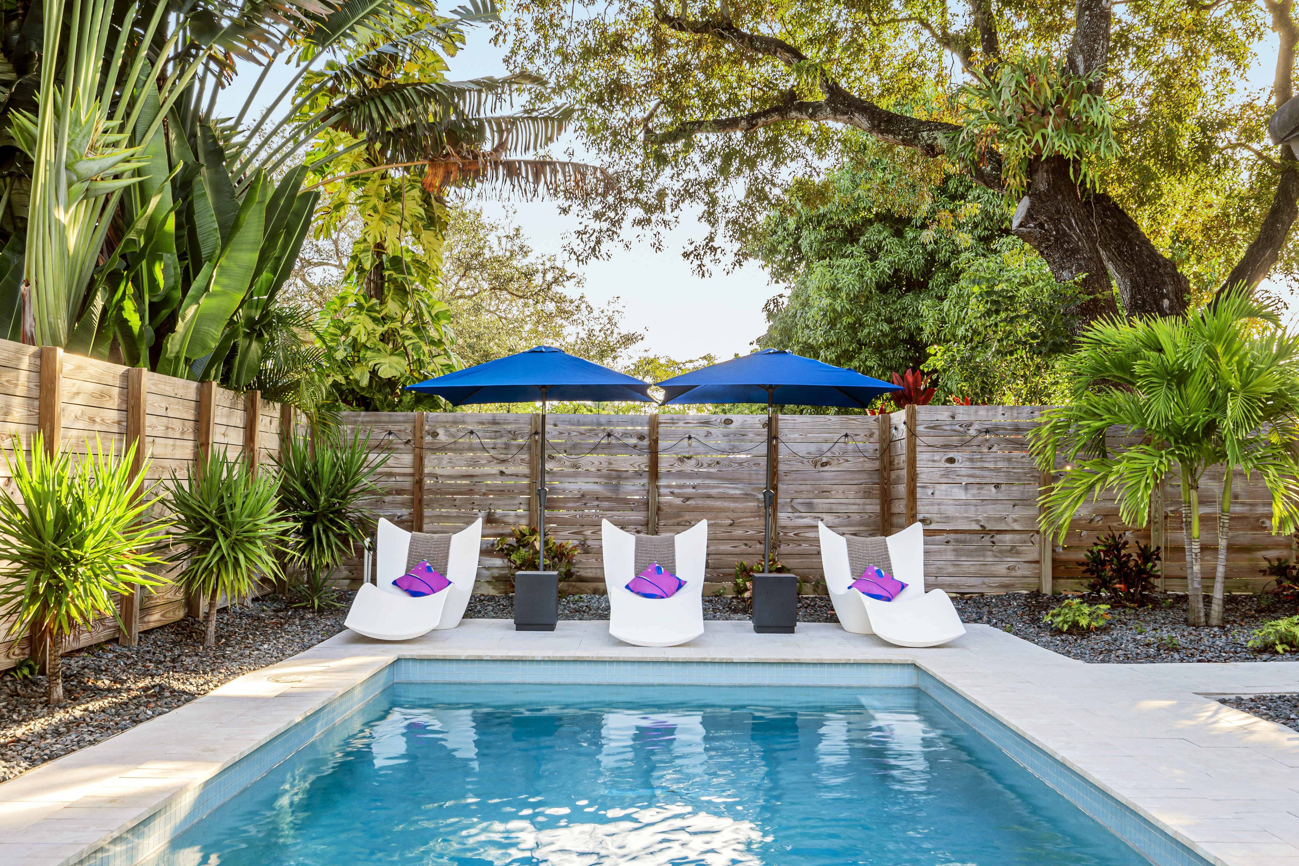 Pool area featuring three lounge chairs and umbrellas