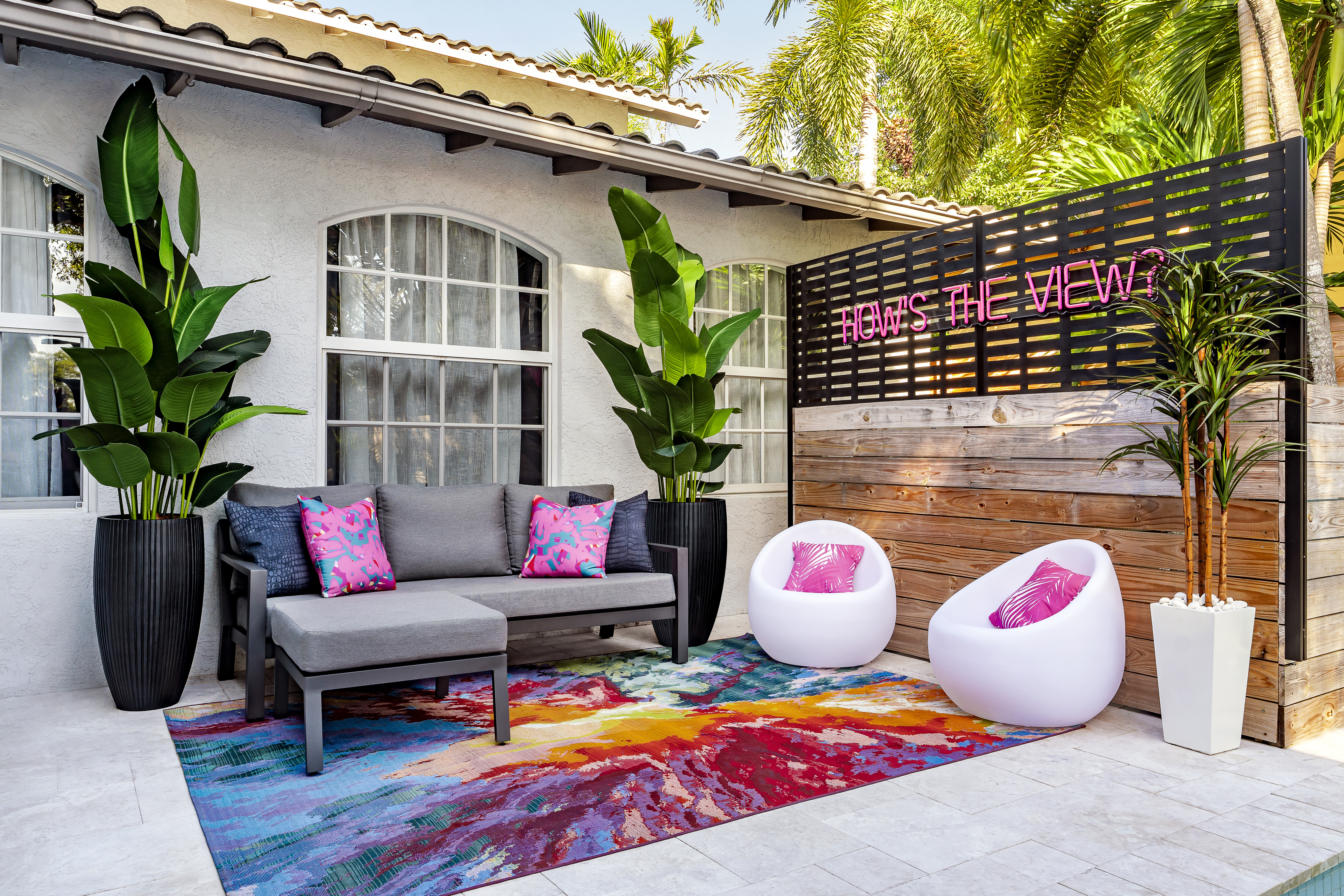 La La Land patio area with couch, chairs and neon sign