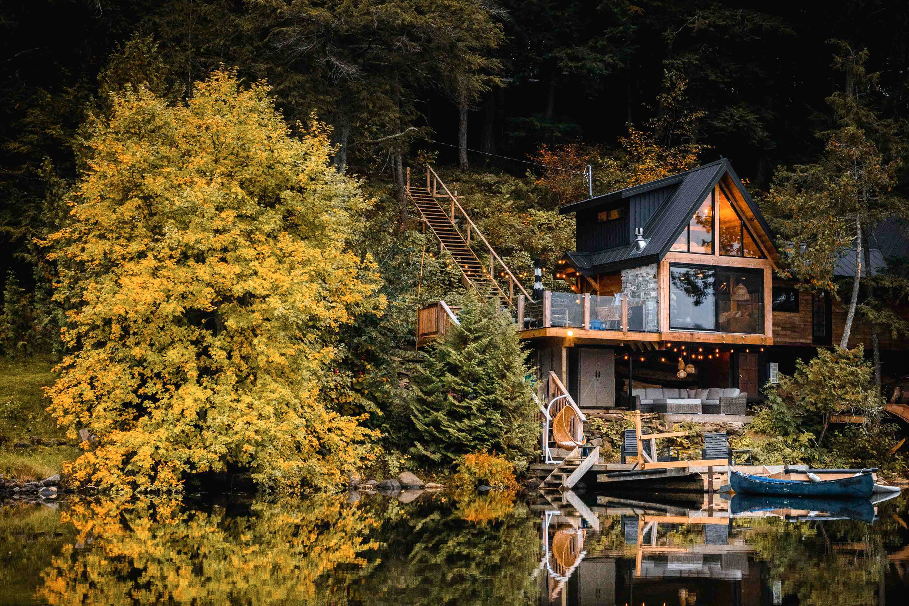 Exterior shot of an A-frame cabin on the shore of a lake in Utterson, Canada.