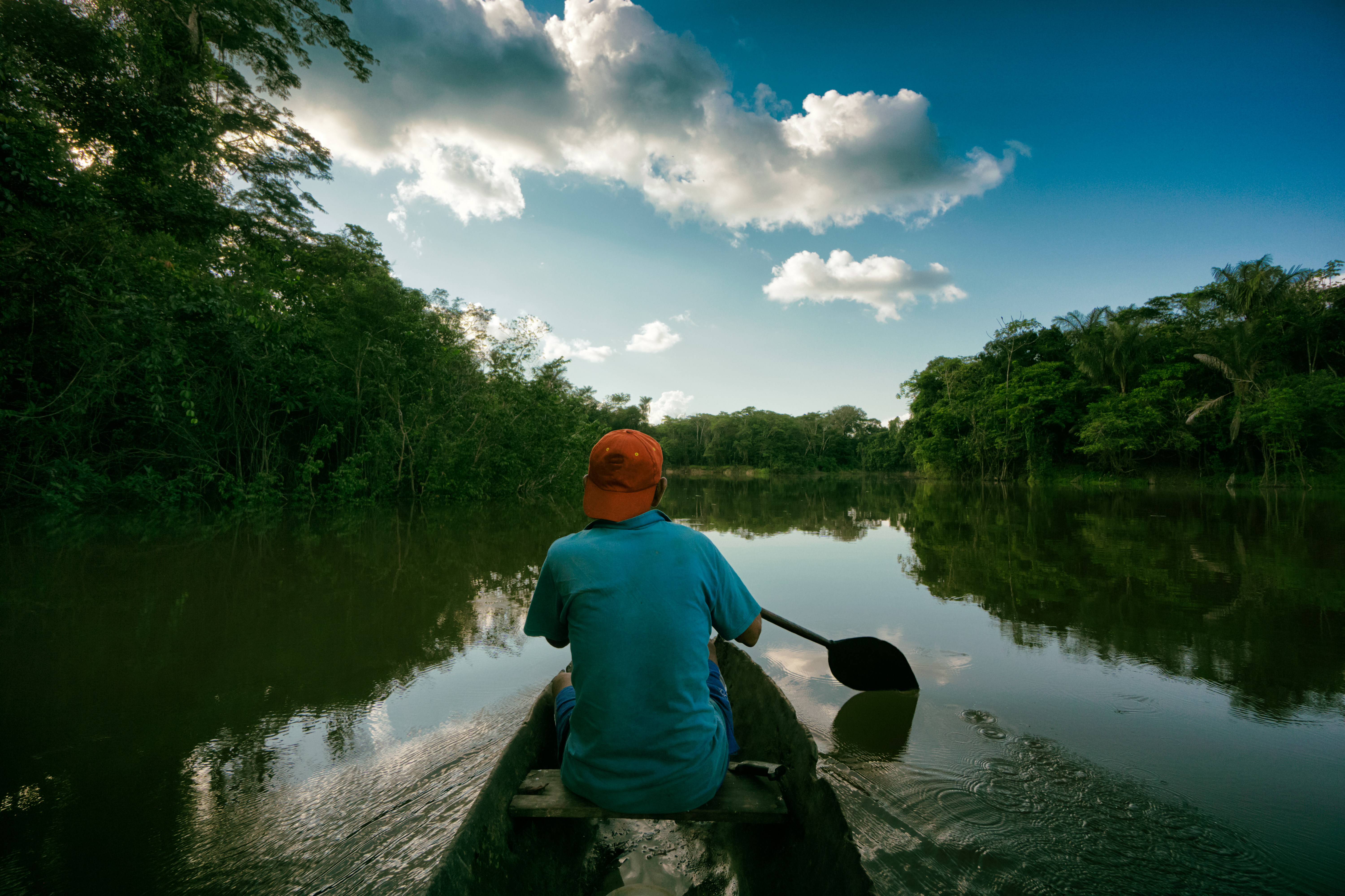 Pescador en una canoa pequeña en medio del Rio Maniti en el Amazonas