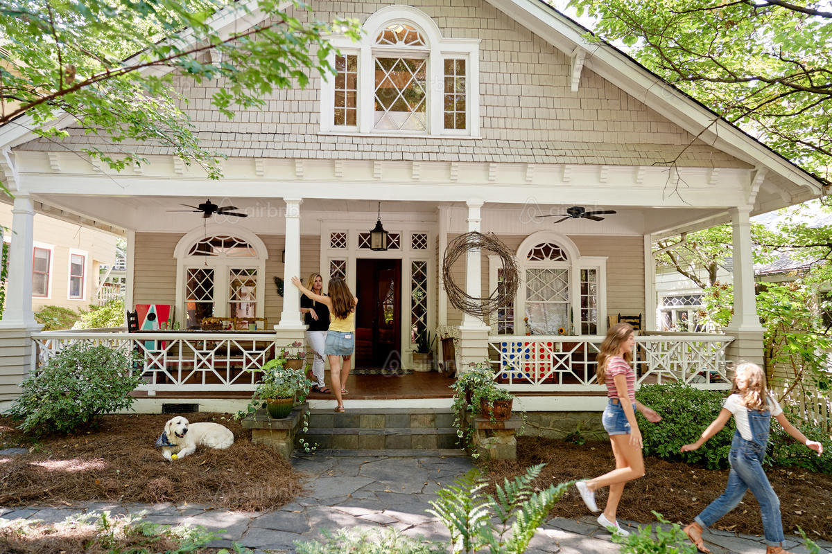 Family playing on the front porch of a house
