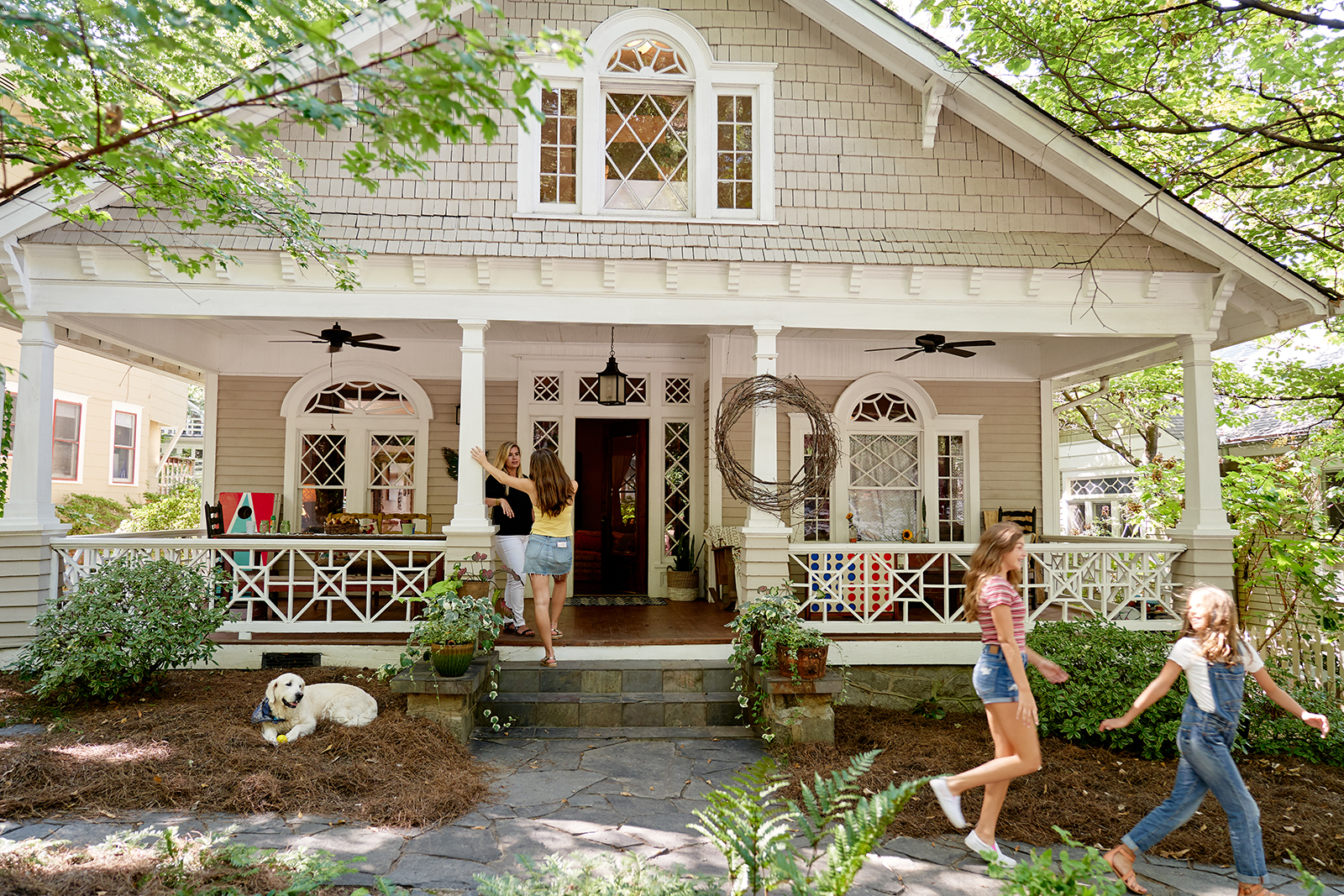 Family playing on the front porch of a home.