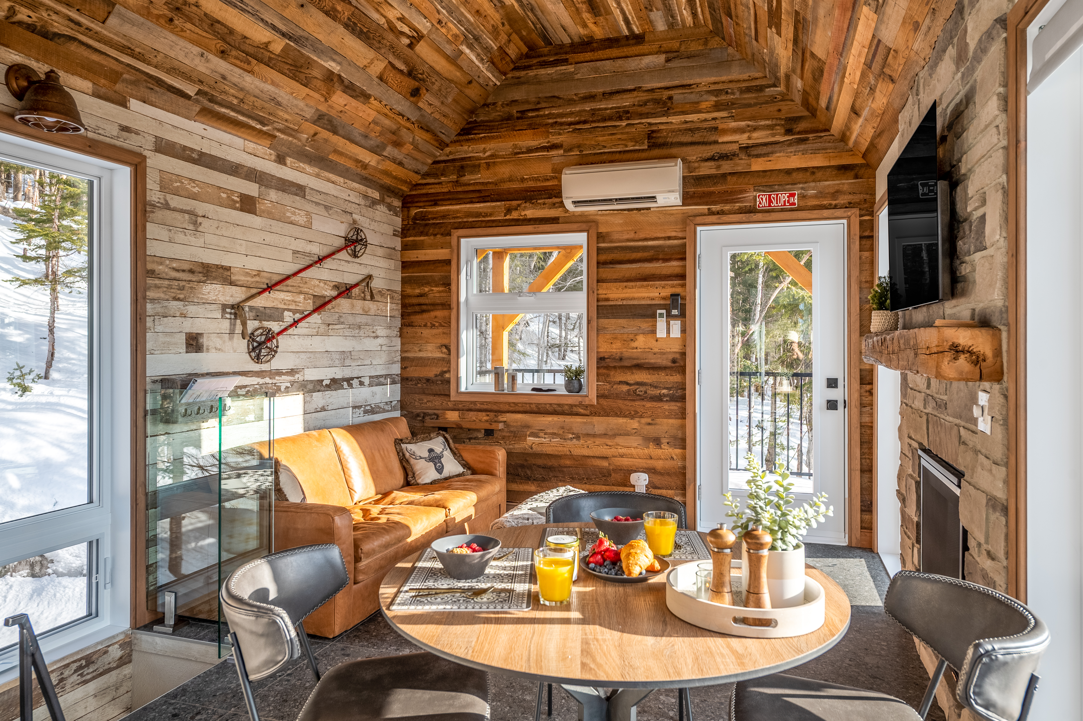 A cabin home living room including a table and couch interiors. 