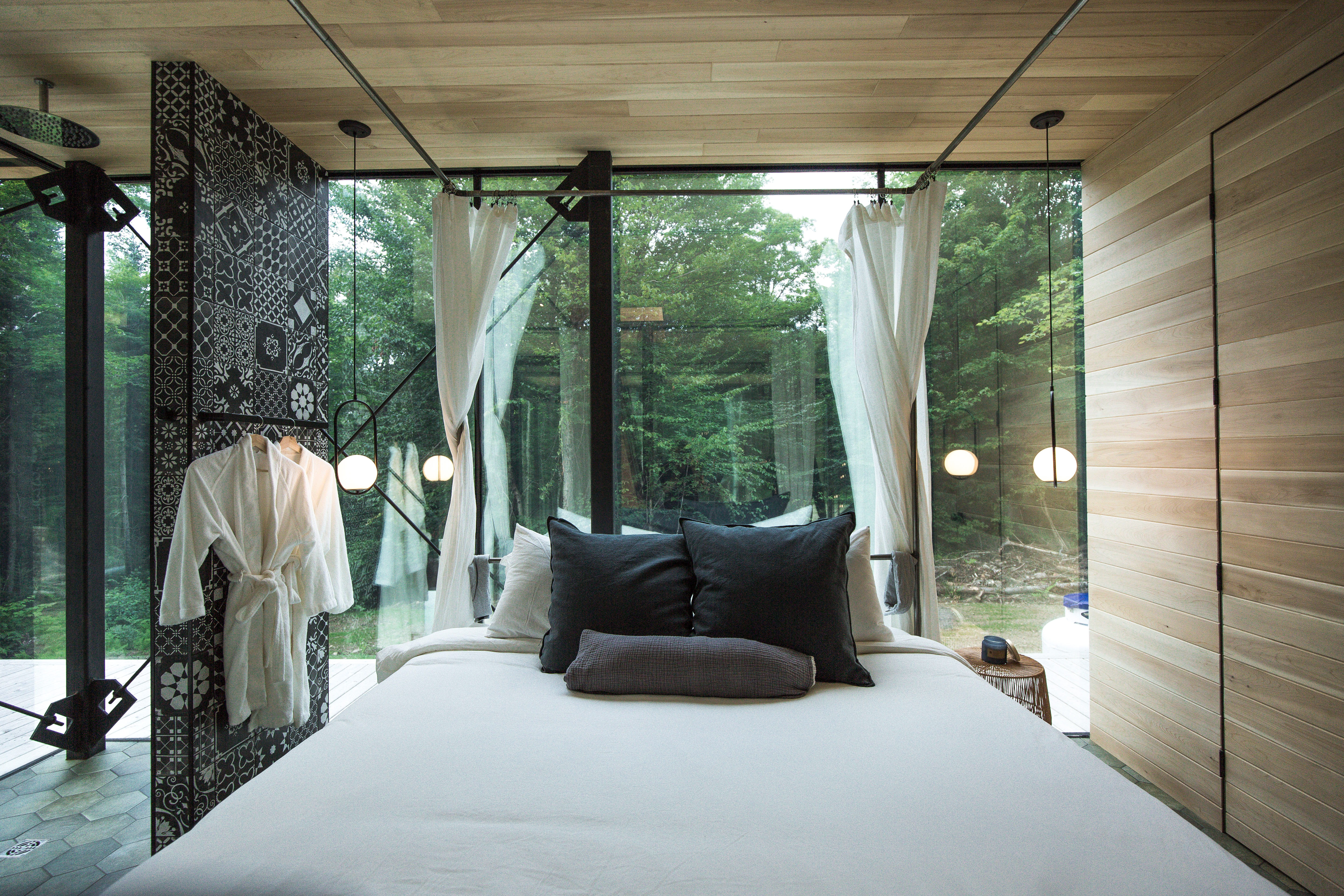 An open concept bedroom with  facing a forest. 