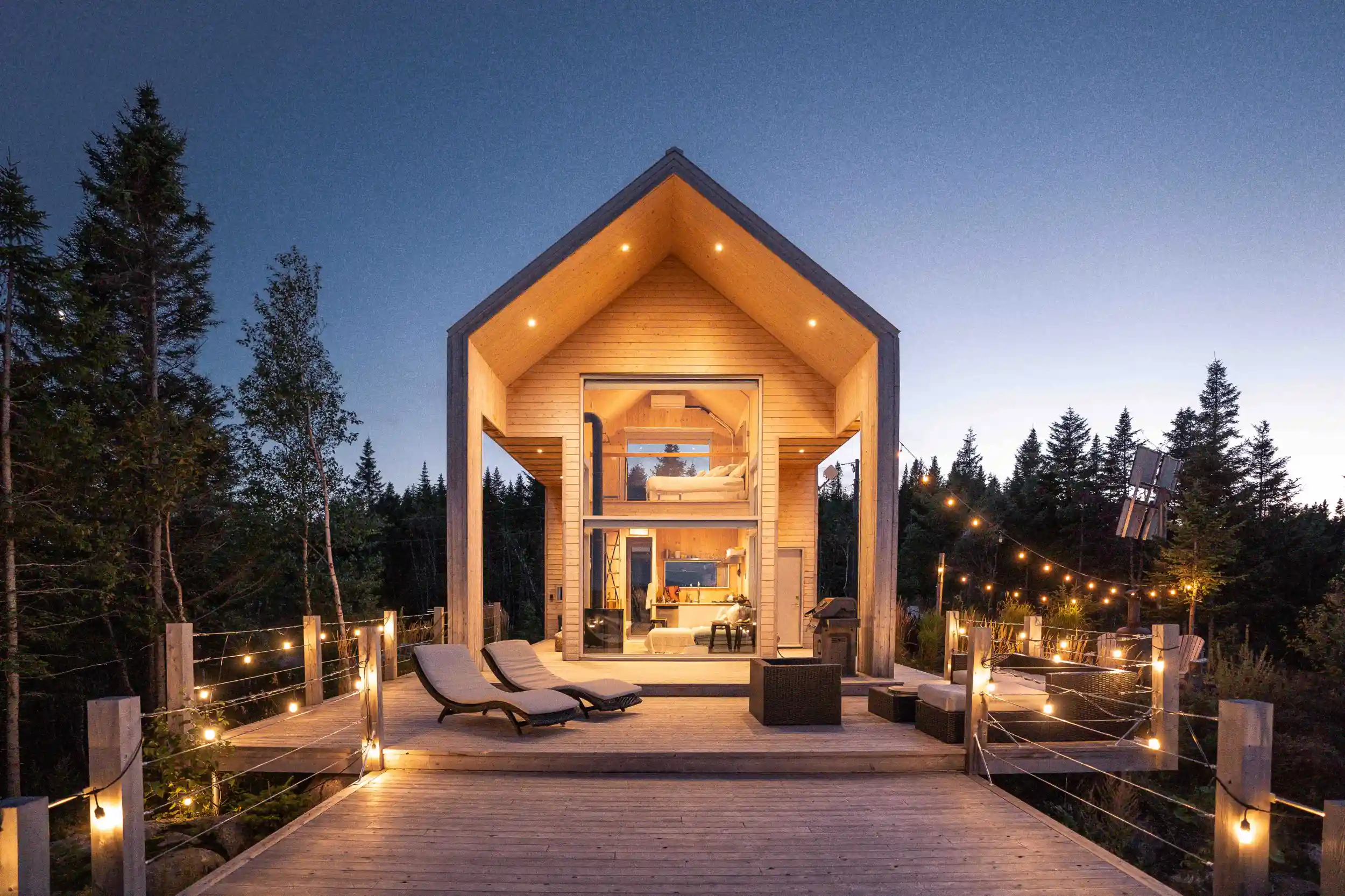 An open-concept cabin with a deck during twilight.