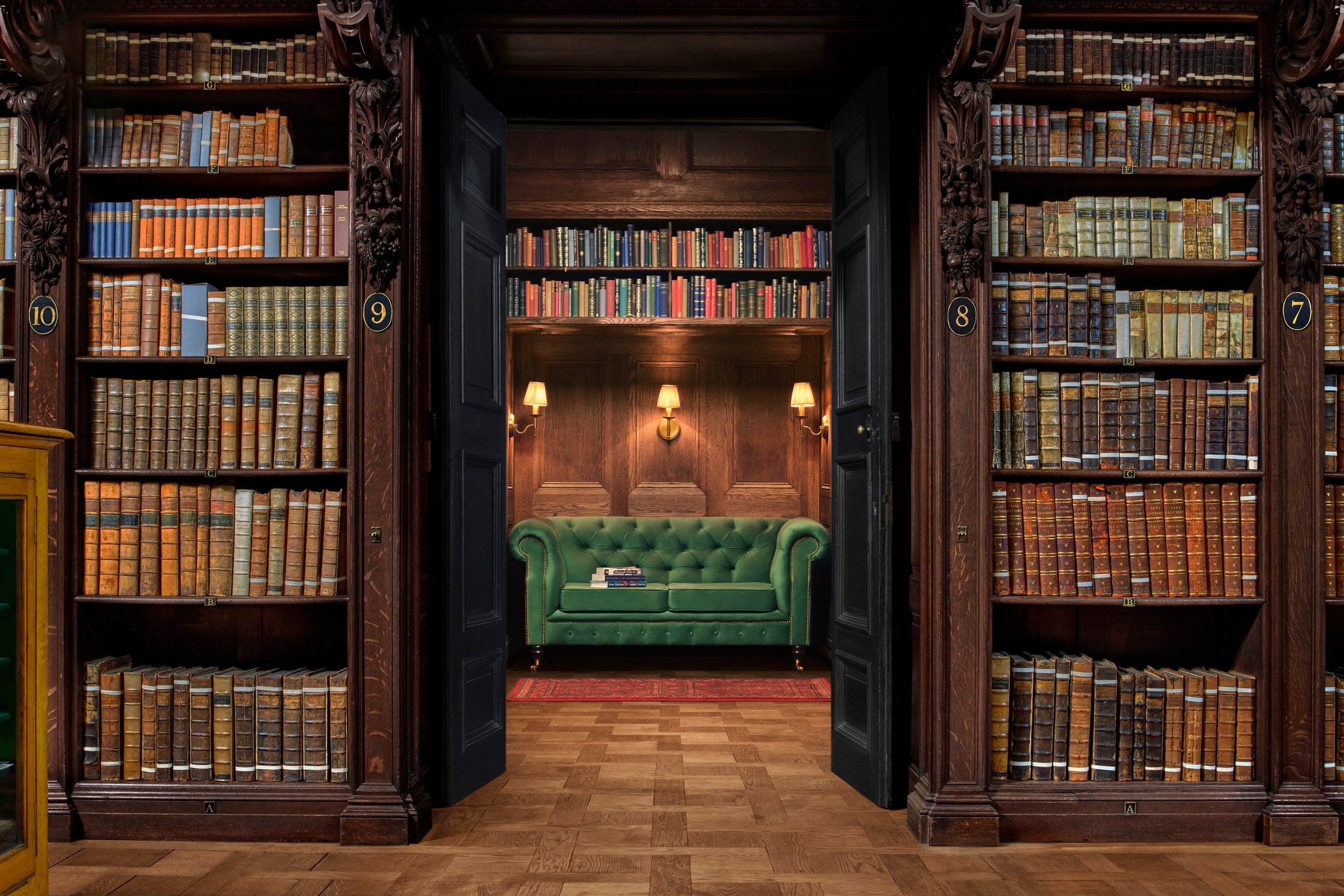 Shot of the reading room in Saint Paul's Cathedral, showing some of the historic volumes and a cosy reading nook with a green sofa.