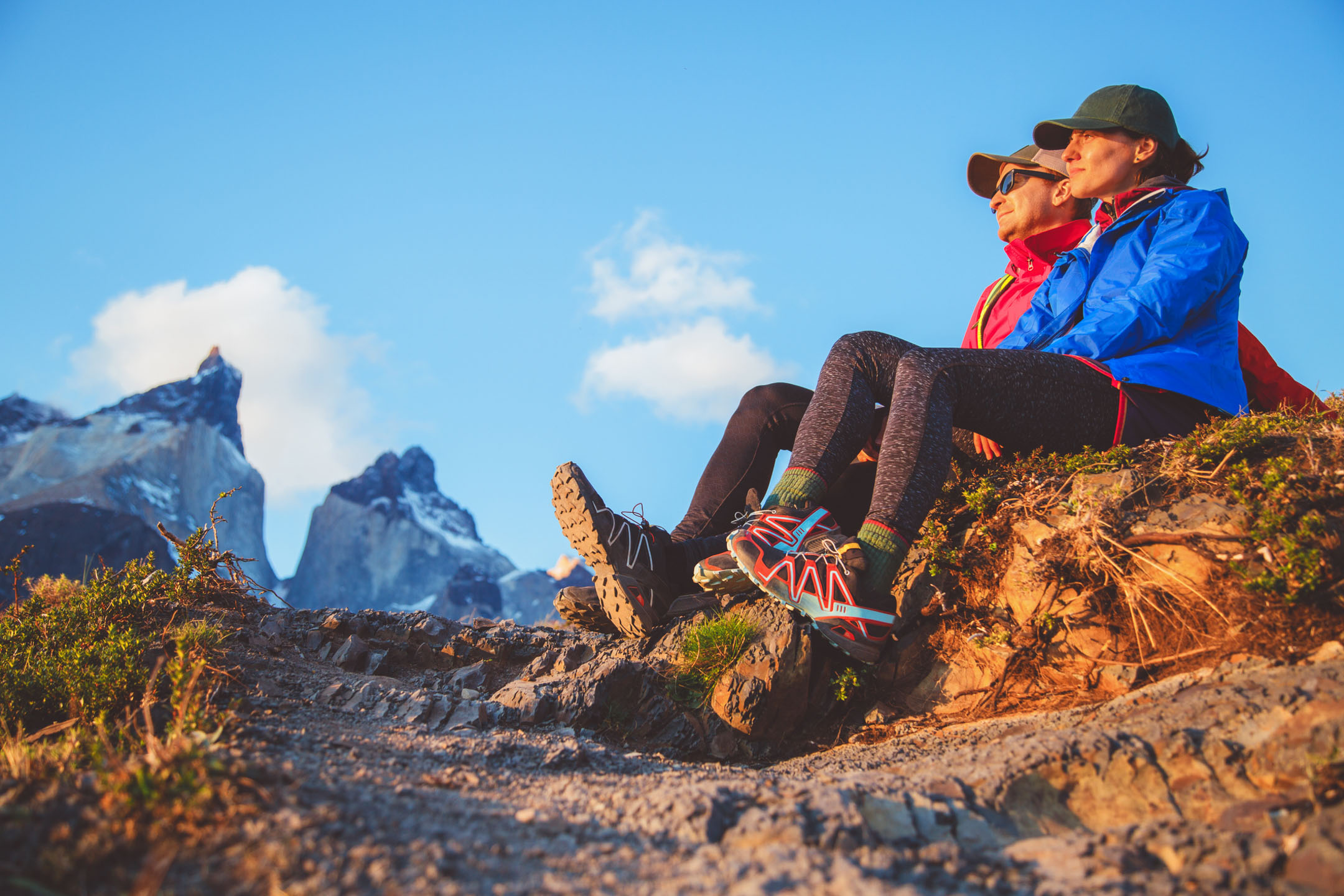Two hikers in Torres del Paine sitting and watching sunset