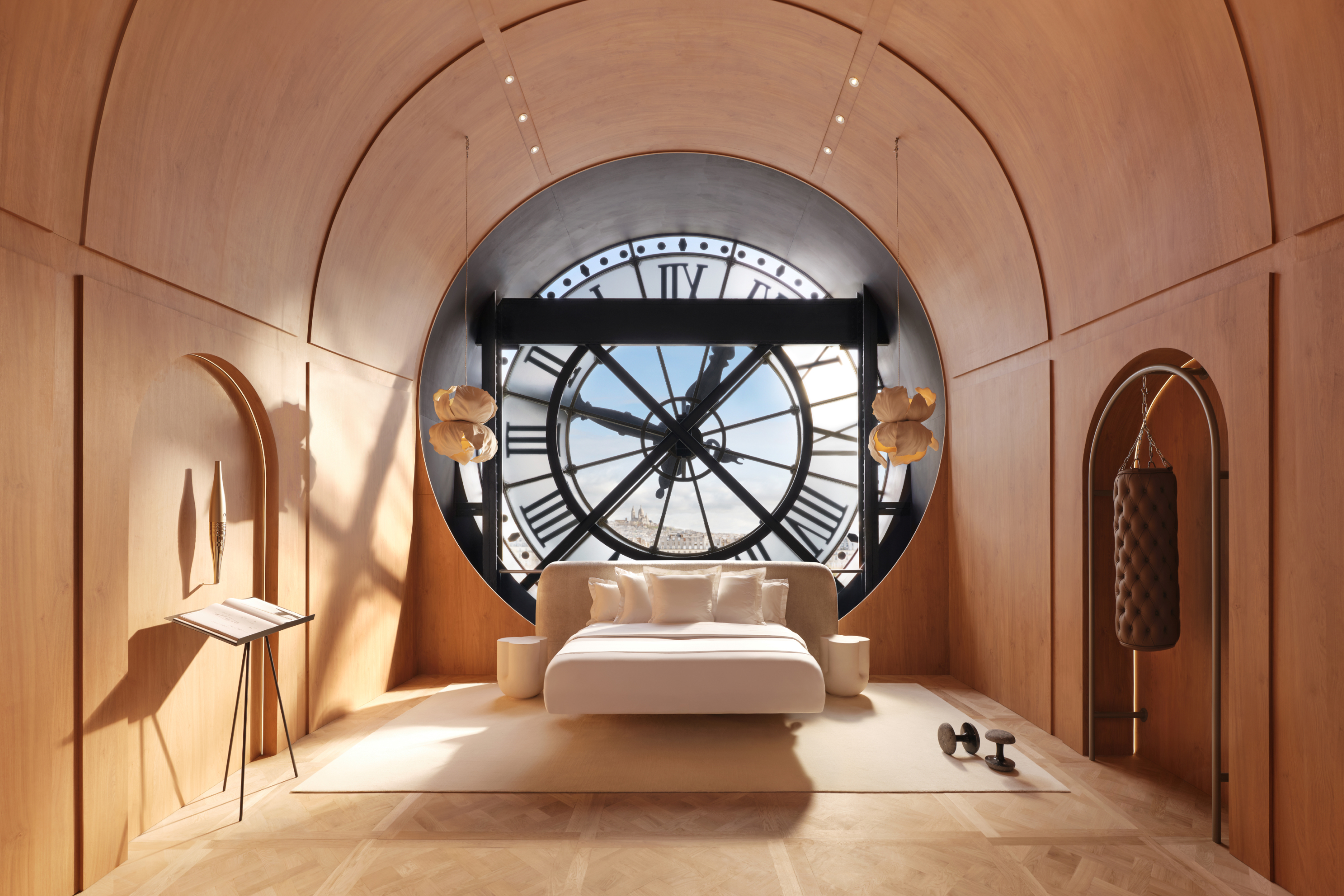 White bed against a large clock face window, in a wood paneled monochromatic bedroom.