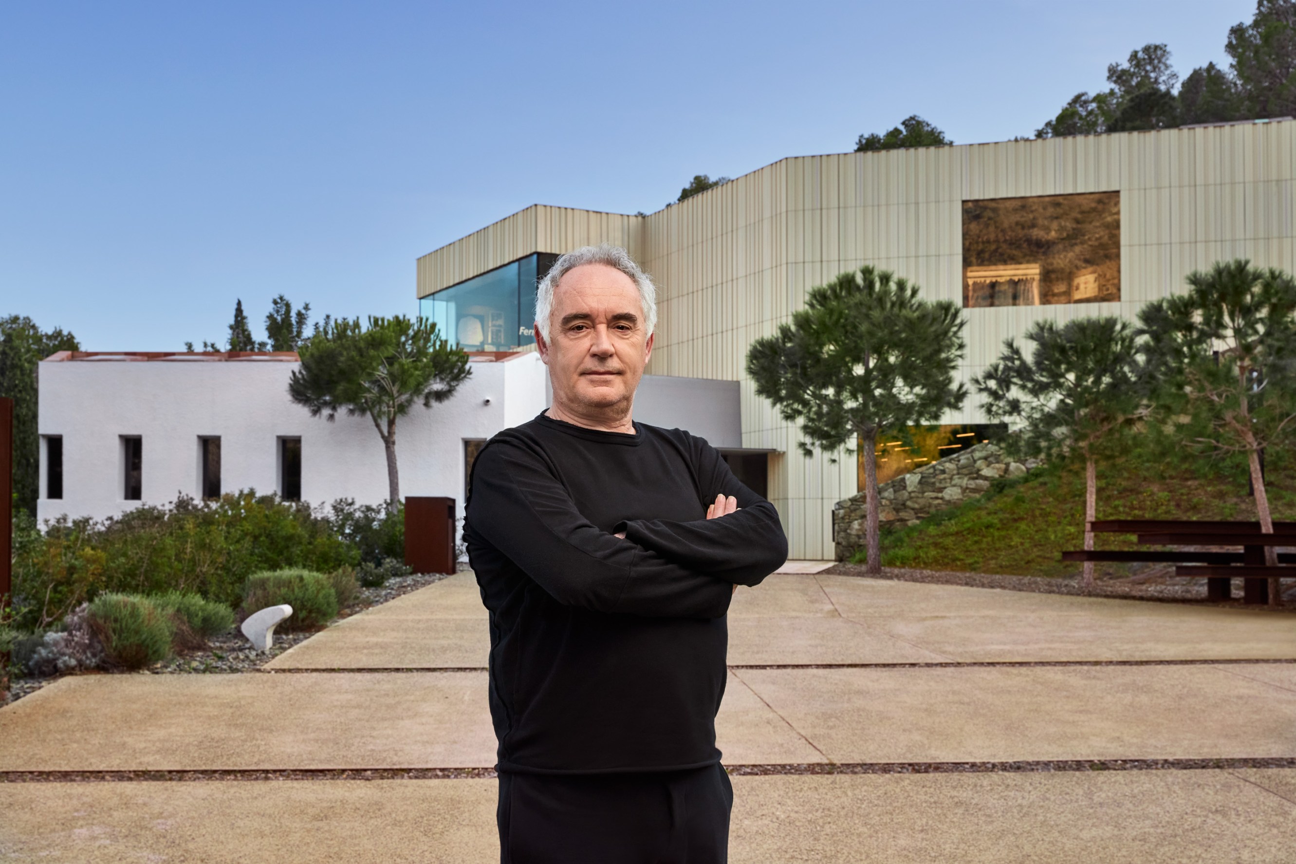 Chef Ferran Adrià standing in front of the elBulli1846 building, a modern, two story structure.