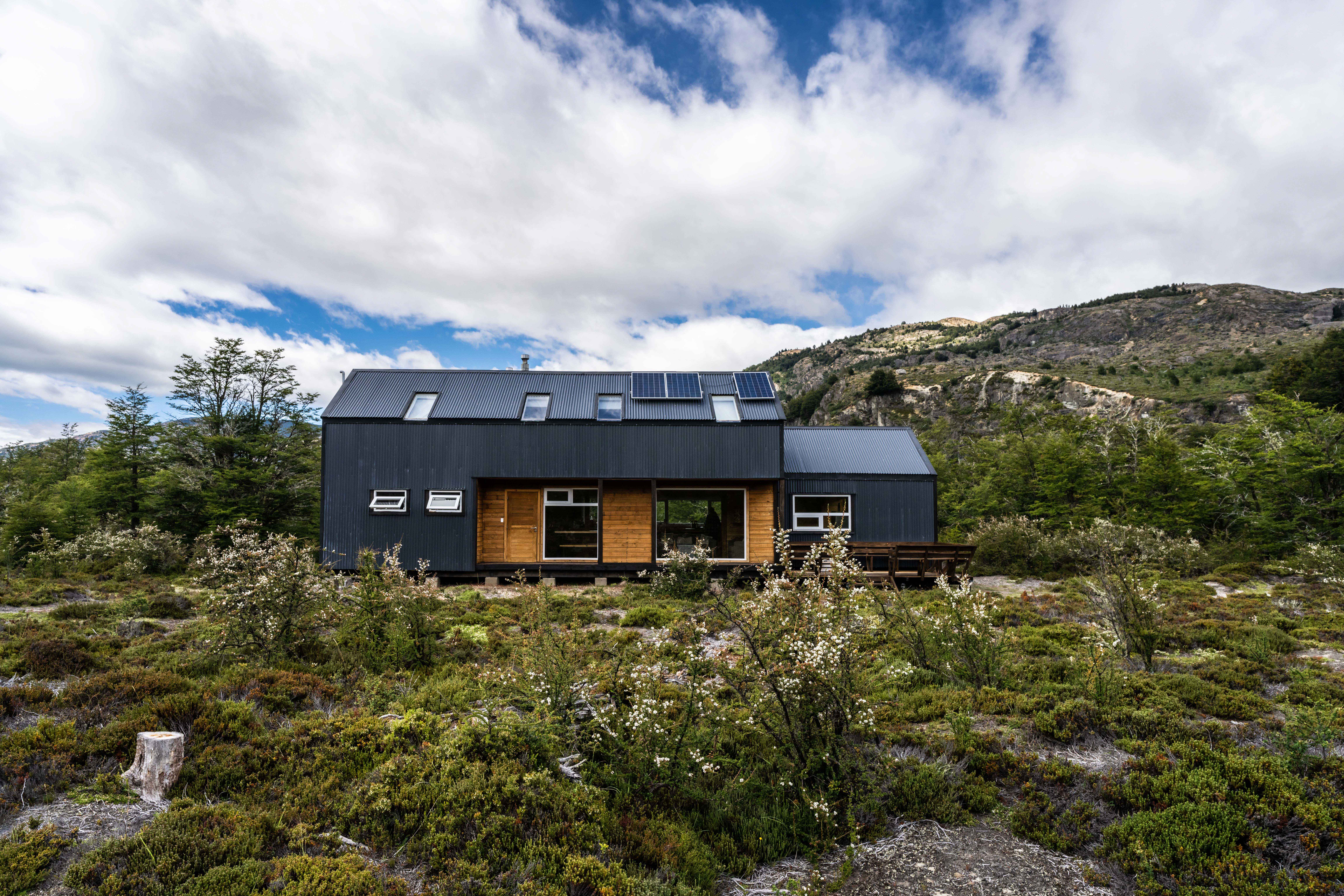 View of a black container home in the middle of the mountains of Chile