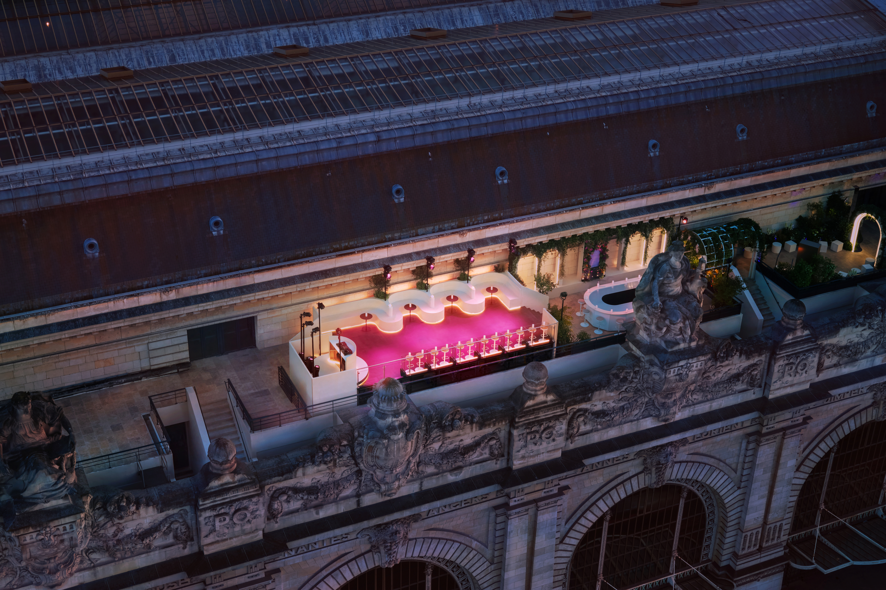 Aerial view of the terrace lit up at night, showing the tasting bar and stage area.