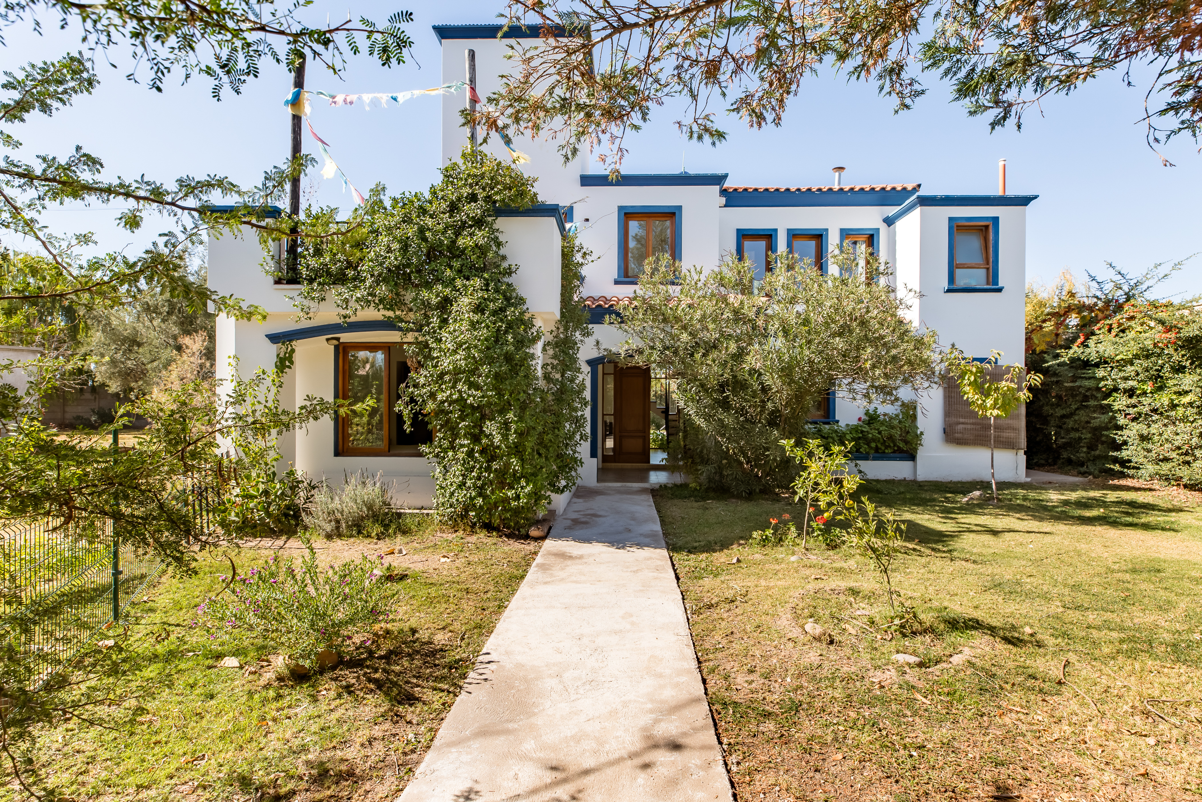 Front view of a white two floor home in the middle of Luján de Cuyo, Argentina.