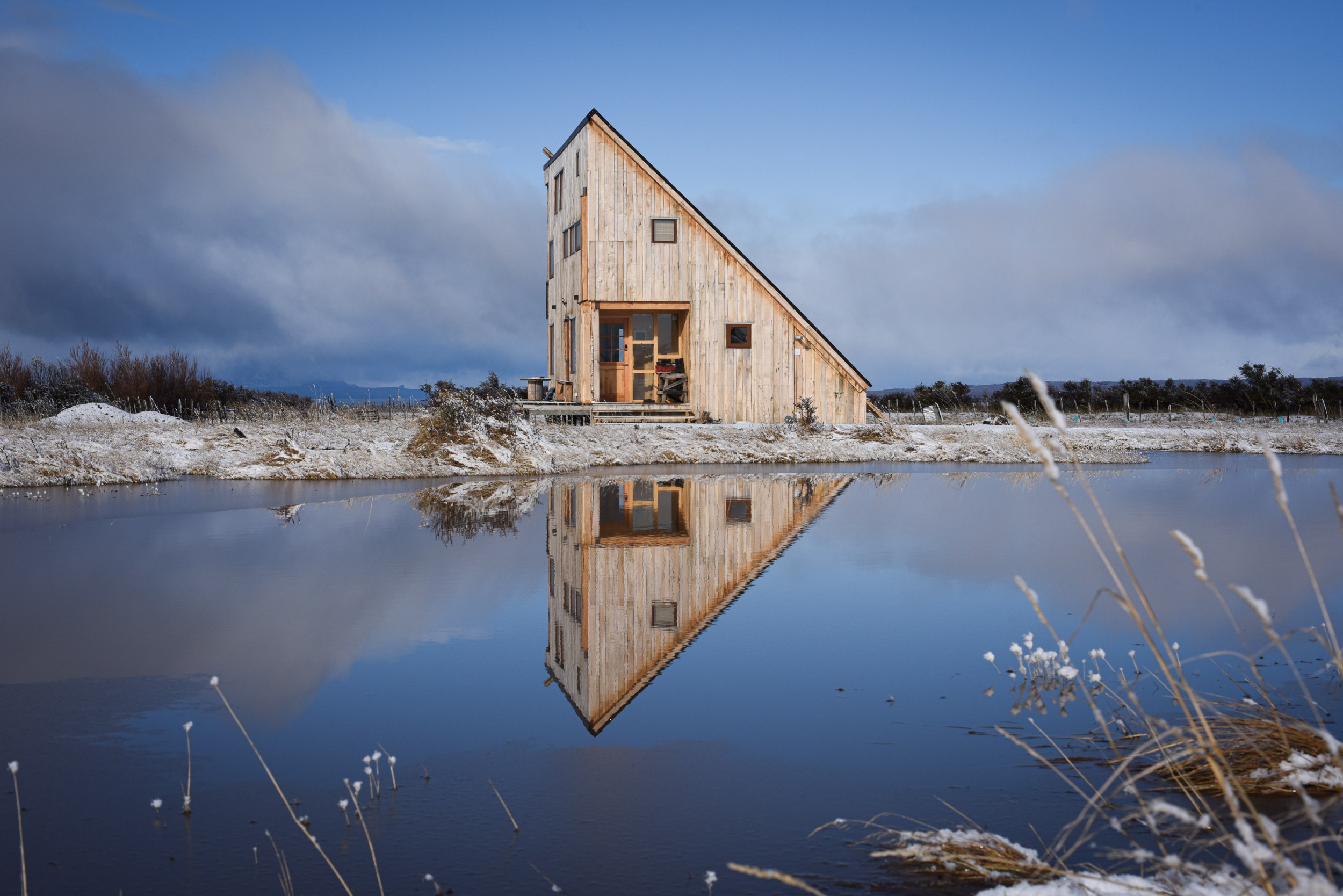 Front view of a cabin behind the lake in the winter of Puerto Natales, Chile