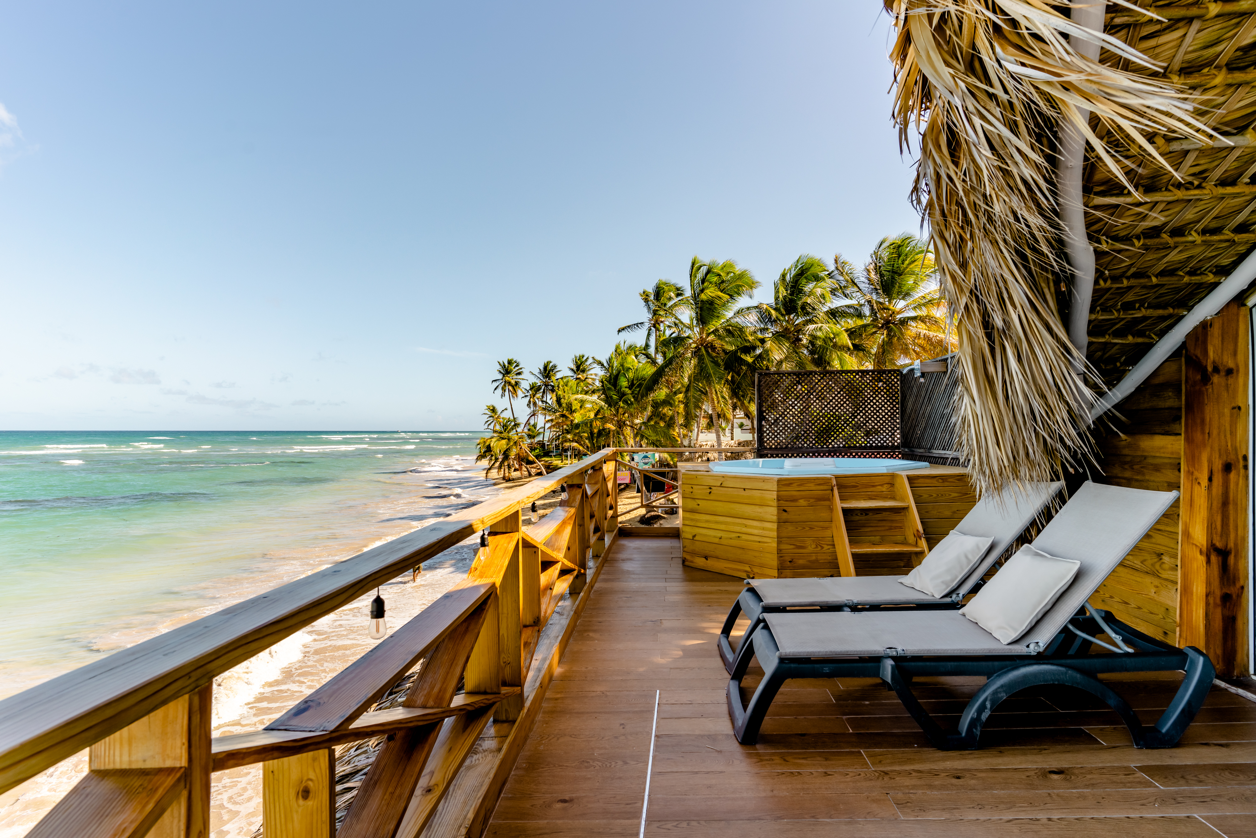 View of the Caribbean sea from a beach cabin terrace with a couple of beach chairs to the right side