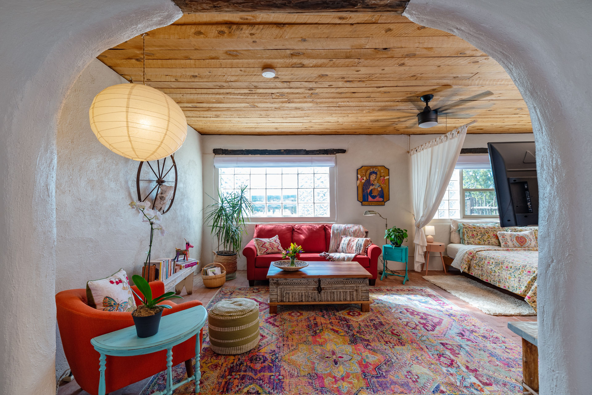 Living room with colorful rug and red couch