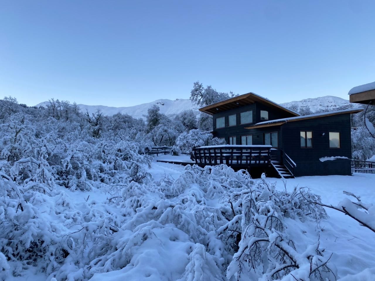 Large house surrounded by snow