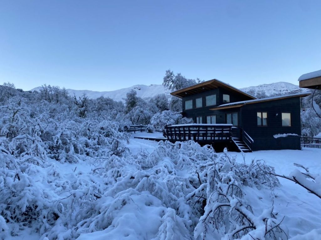 Large house surrounded by snow