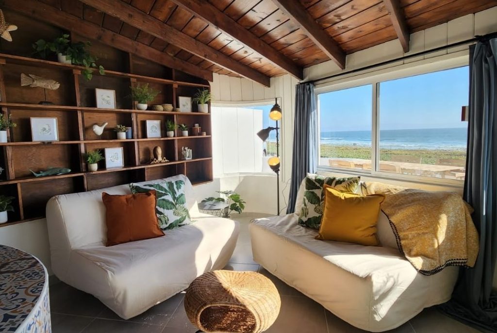 Living room with wooden panels and large windows with an ocean view