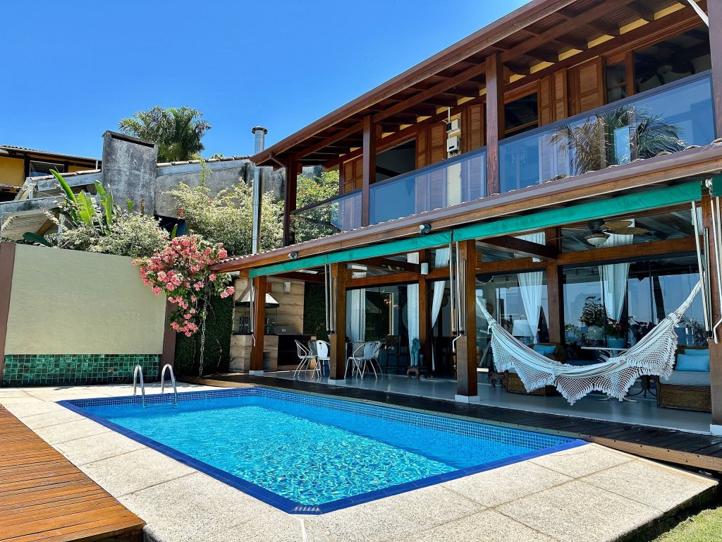 Exterior of a wooden home with a large pool