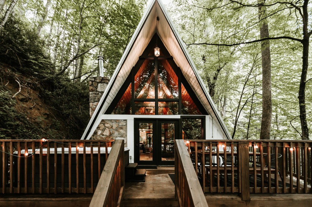 Exterior of A-Frame cabin surrounded by trees