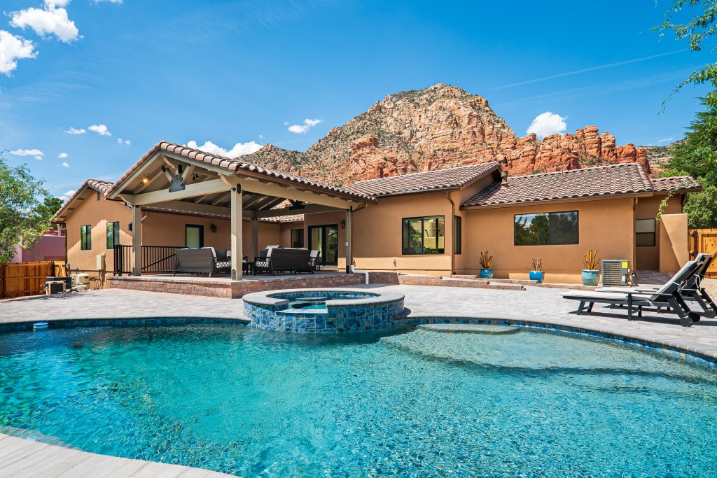 Exterior of clay house with large pool and views of the Red Rocks