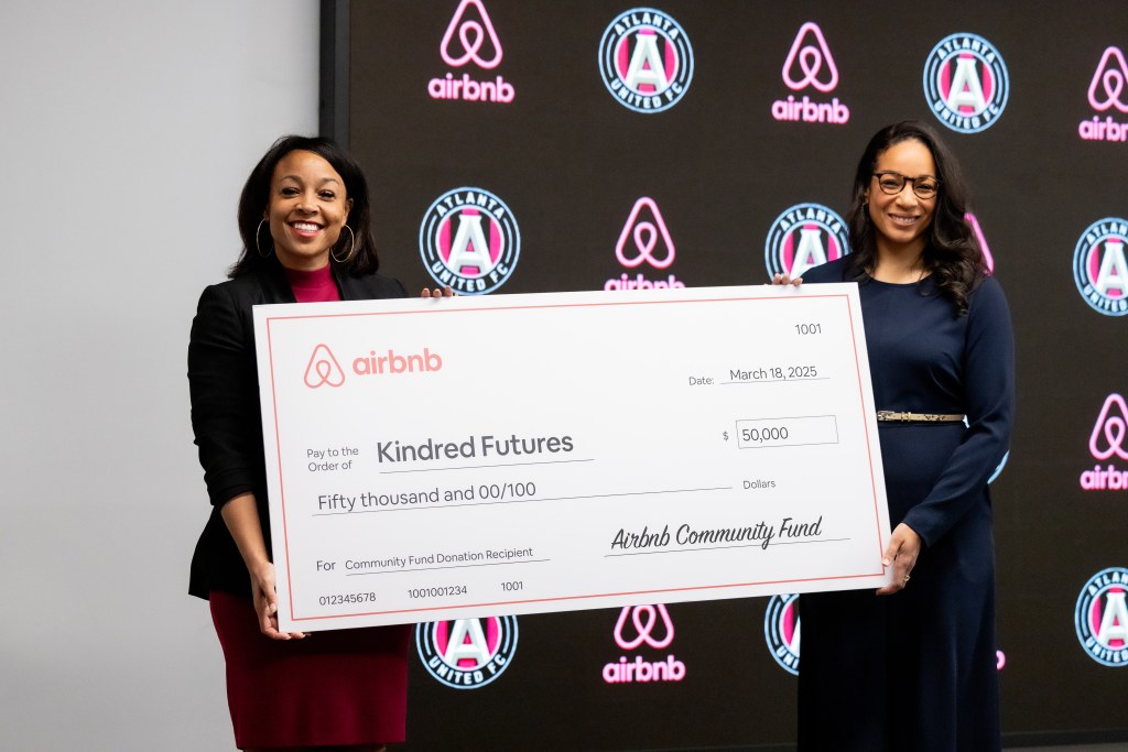 Two women hold a jumbo check for $50,000
