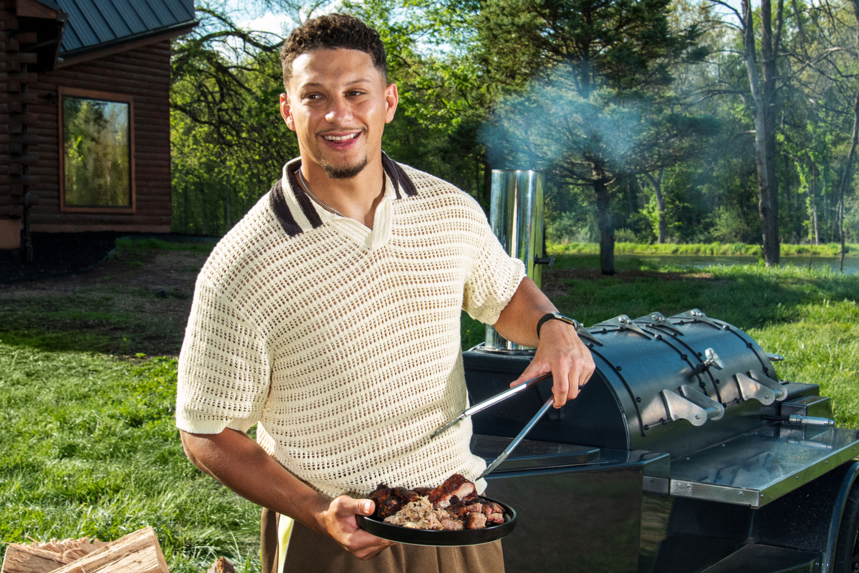 Outdoor barbecue scene with a person preparing grilled meat next to a smoking barbecue grill.