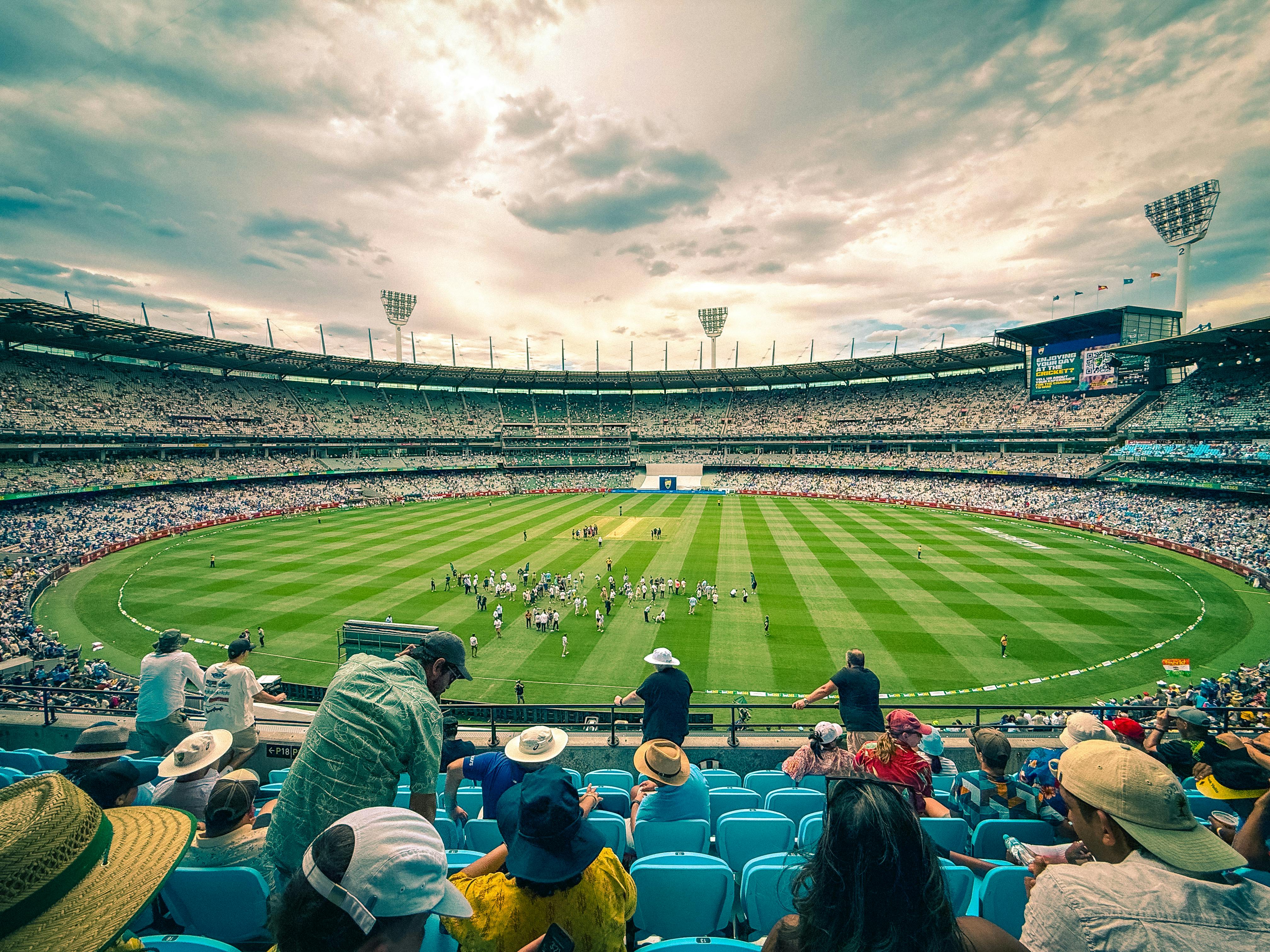 An image of a sporting stadium with fans watching as the sun is setting