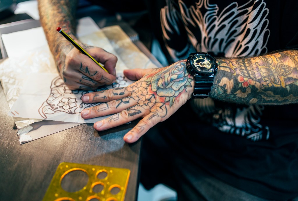Tattoo artist sketching a tattoo stencil