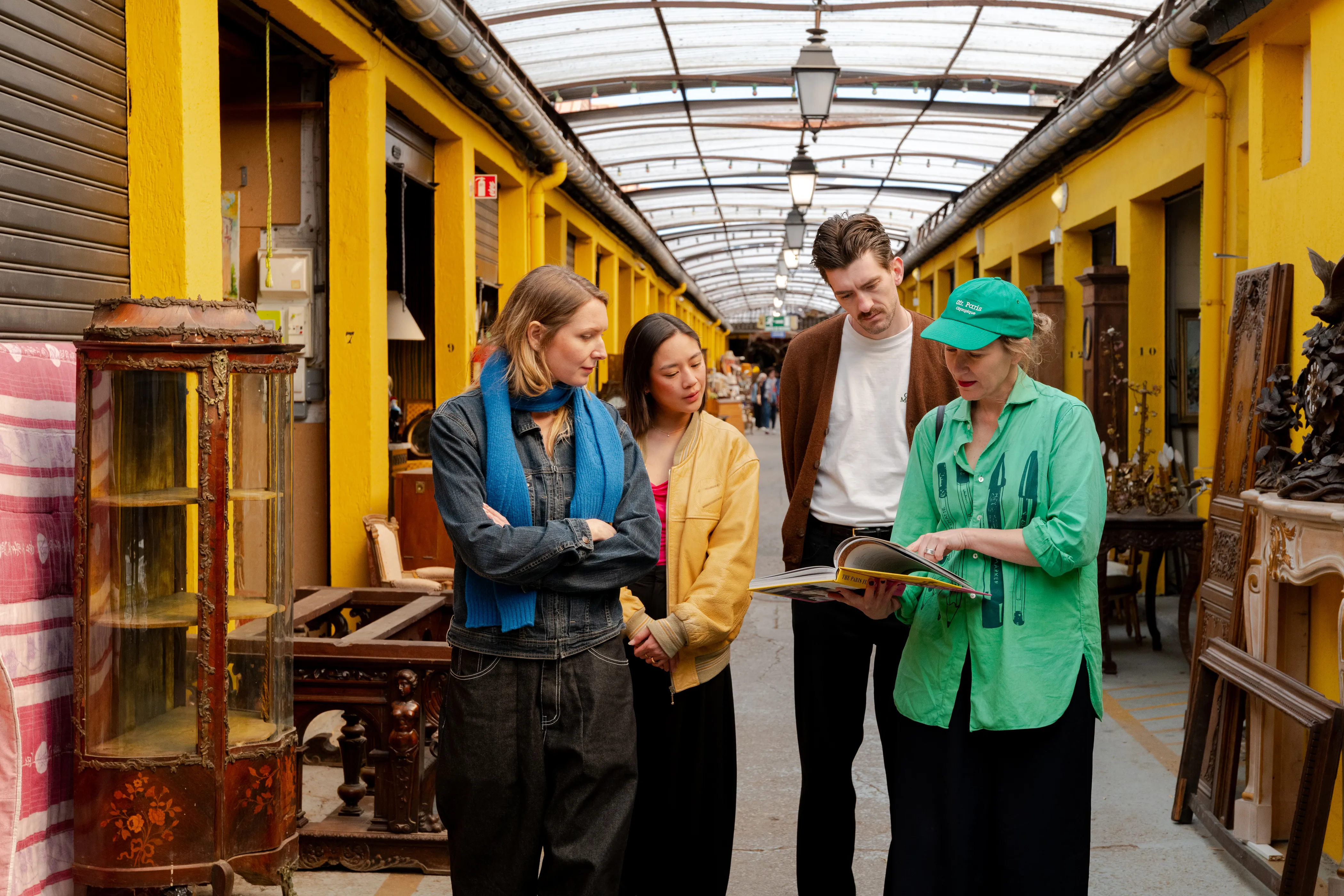 Tour guide showing around a group of people in a flea market