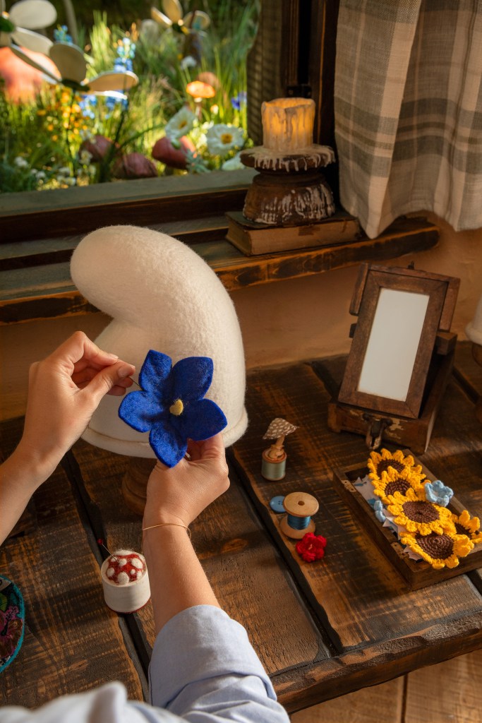 Sombrero blanco de pitufo con una flor azul