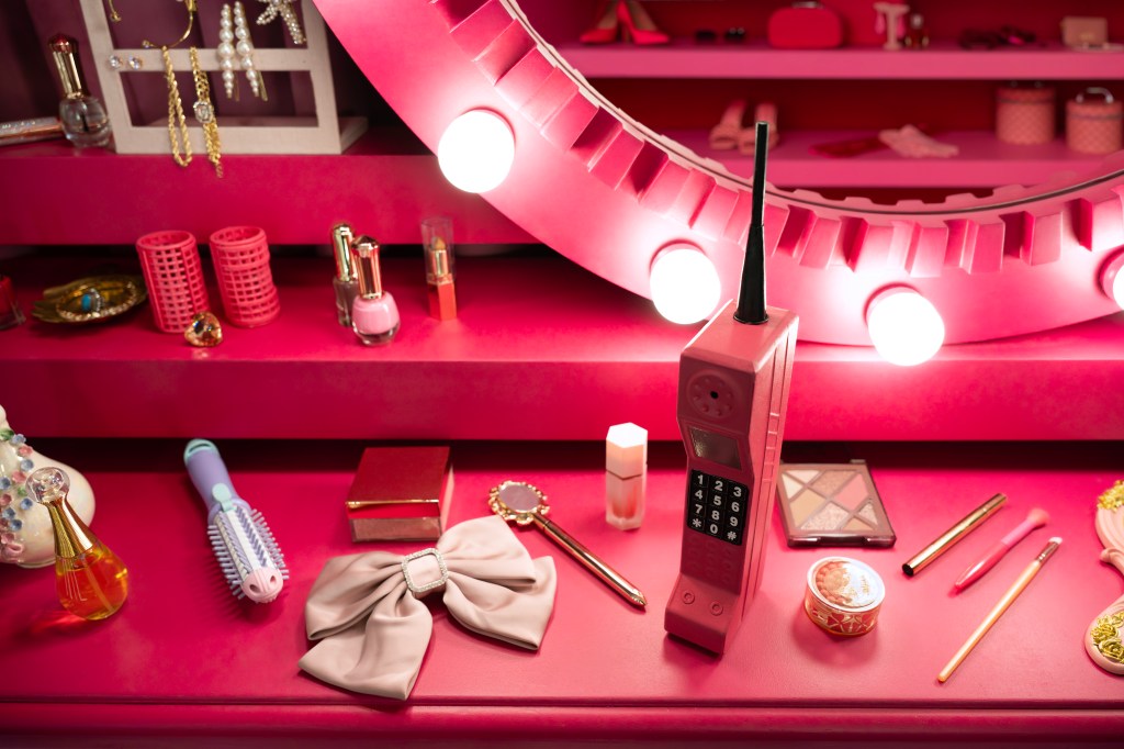 Tocador con un telefono, items de maquillaje y peinado