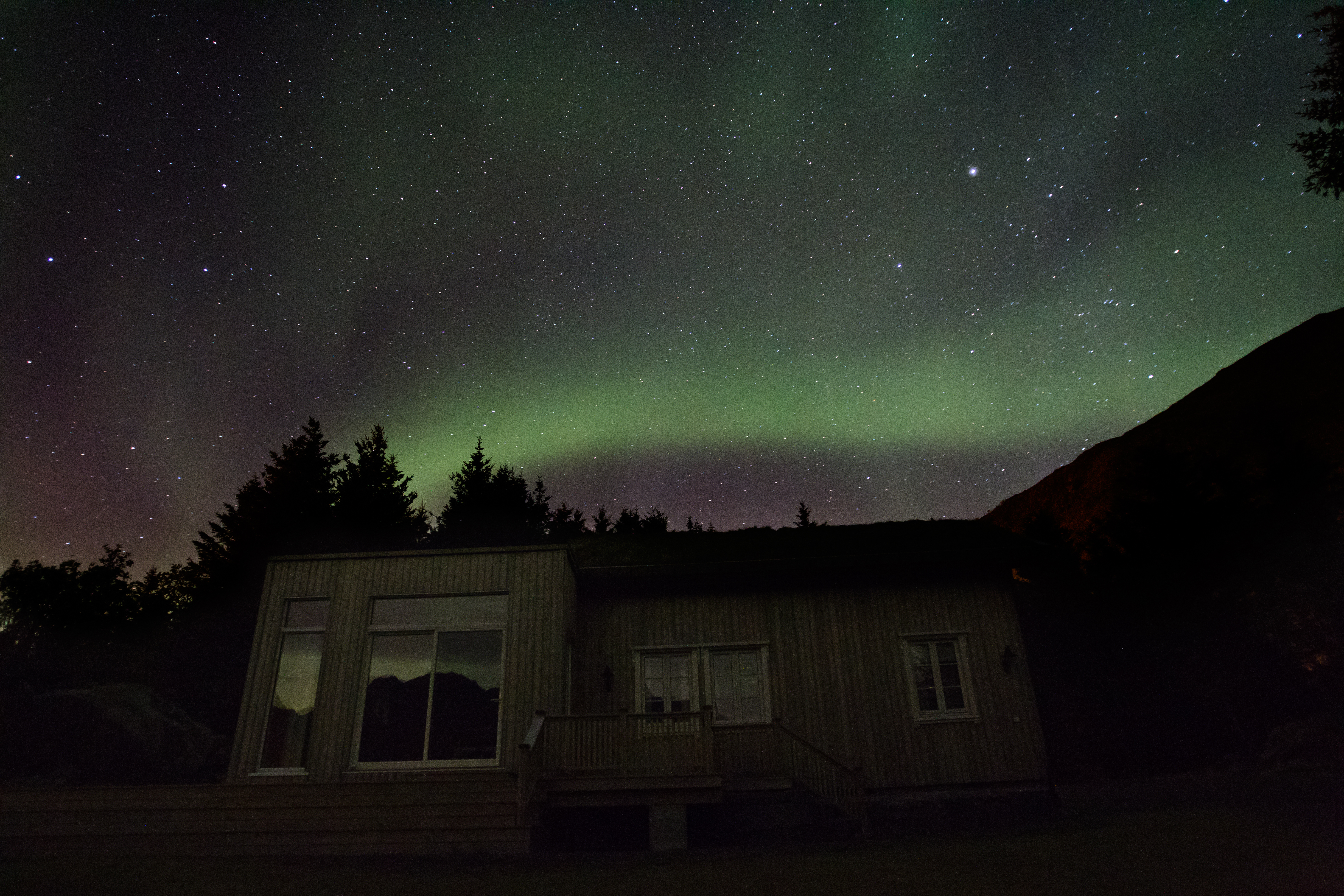 A lodge with Northern Lights above it.