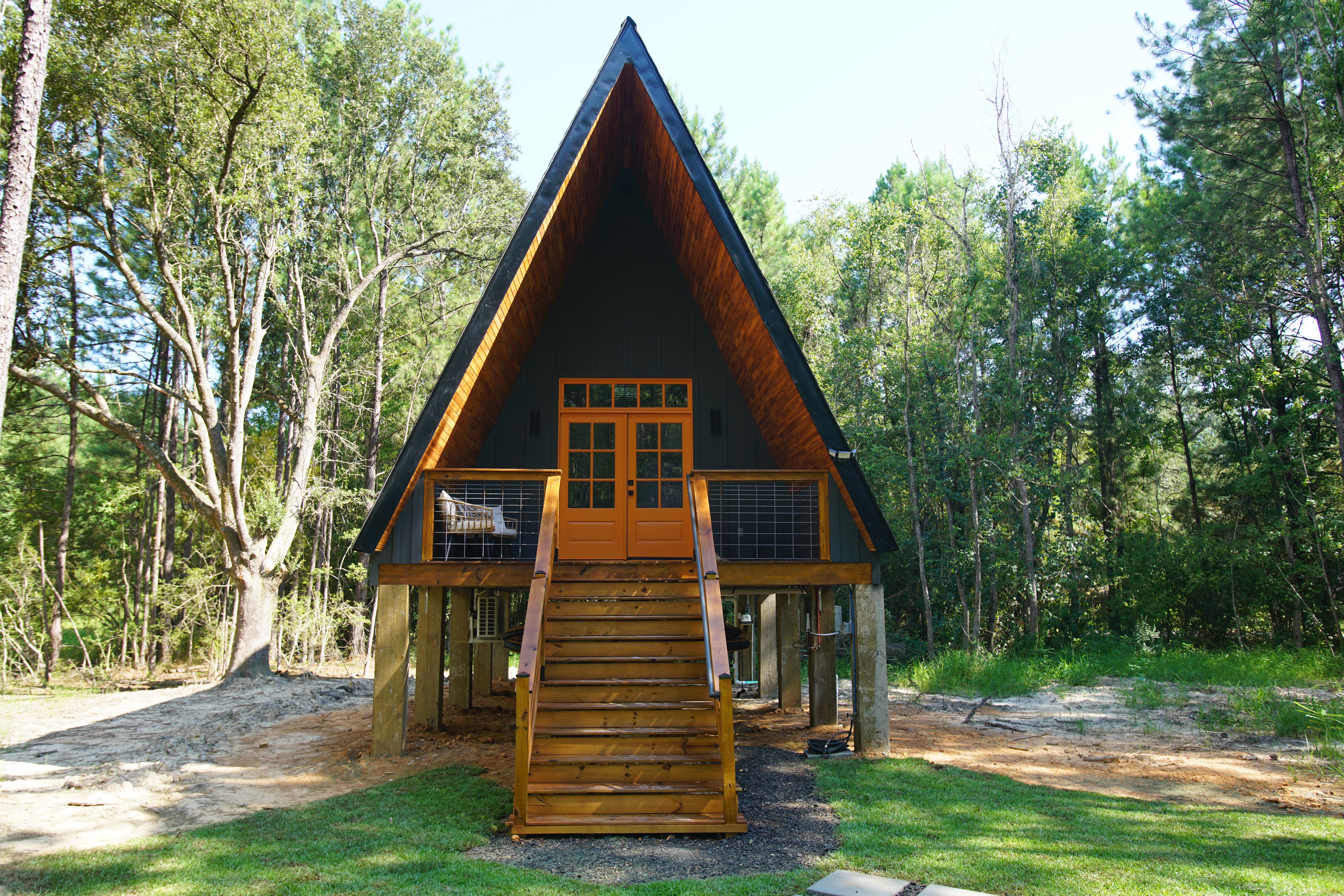 Black and orange a-frame surrounded by green trees.