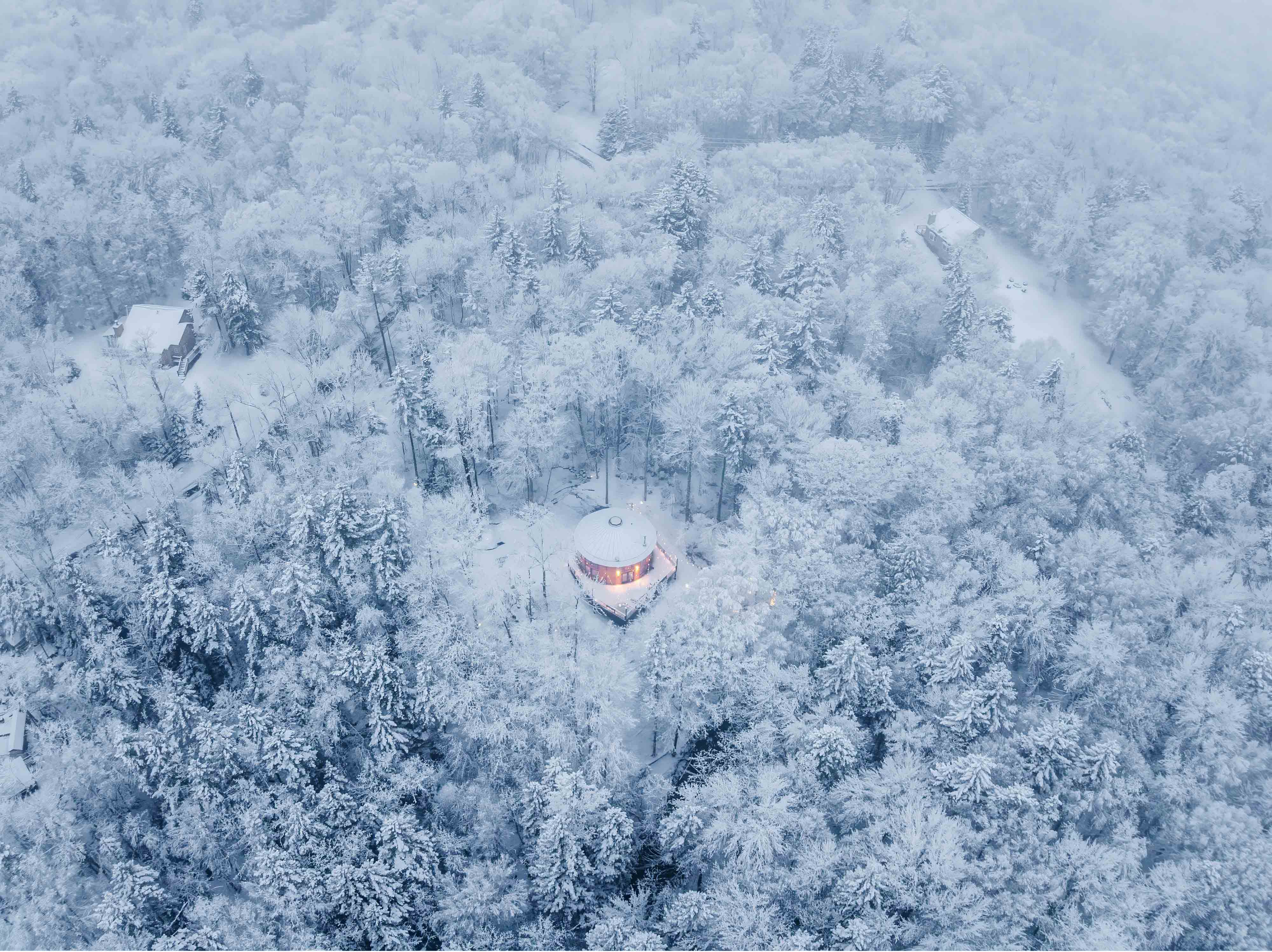 A mountain yurt surrounded by snow.