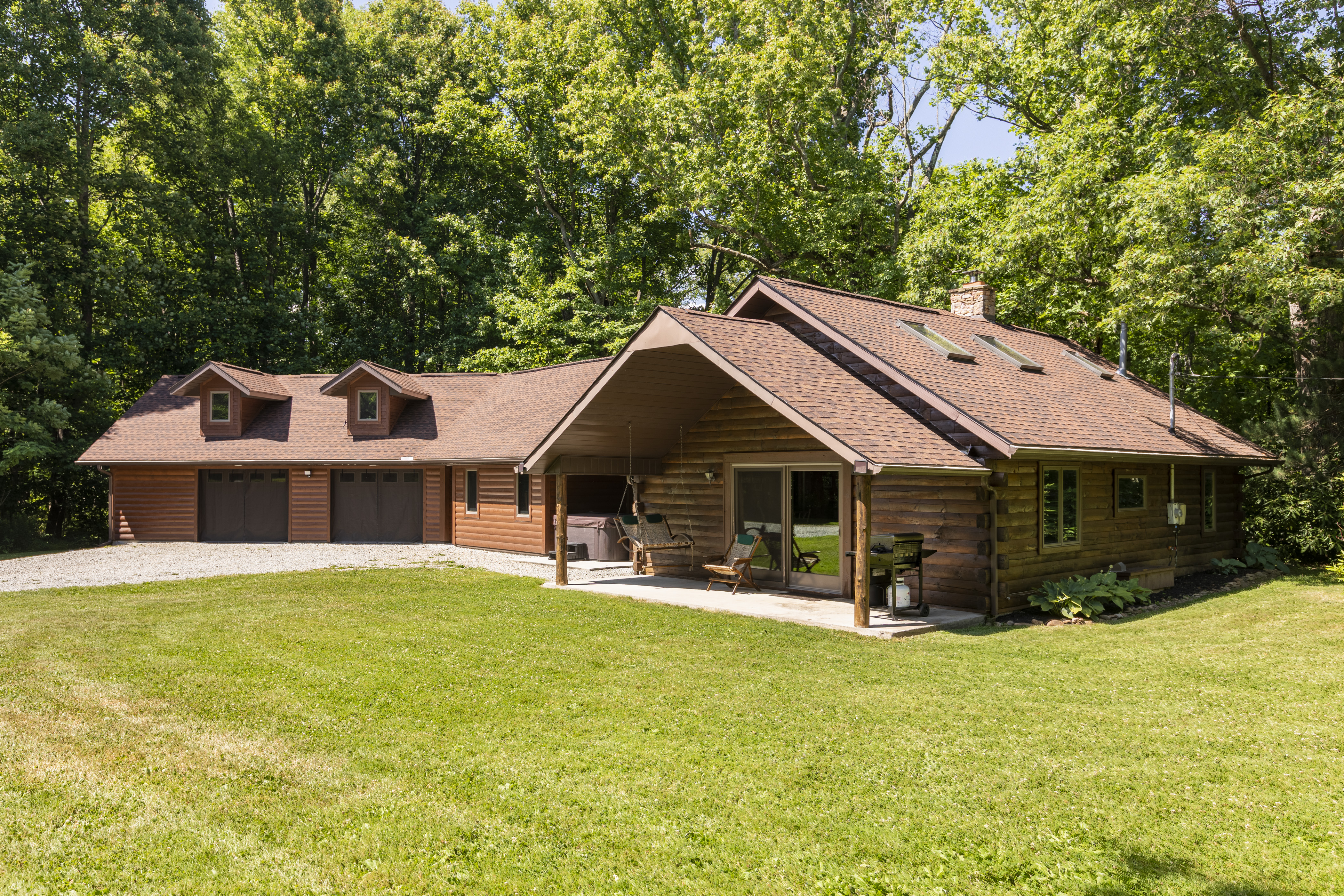 A large wooden cabin surrounded by green trees.