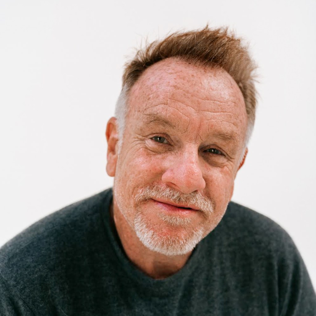 A person wearing a dark gray sweater against a plain white background, upper body visible.