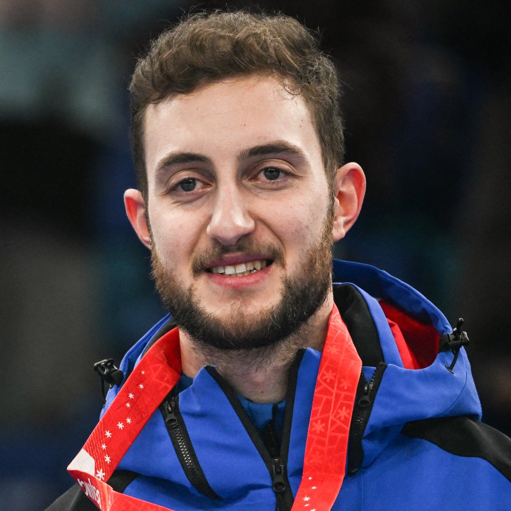An Olympic athlete stand proudly with gold medal during the Beijing Winter Olympics celebration.